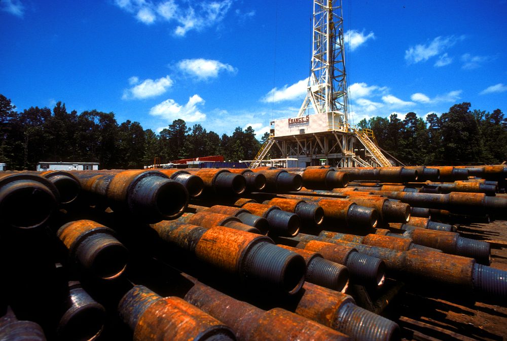 Stacks of coated steel casing at a wellsite